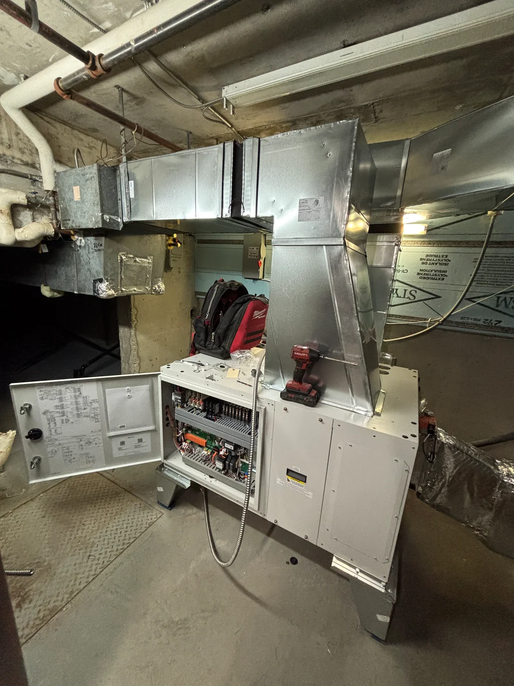 Dehumidification unit at Condo du Fleuve, with an open panel and service tools